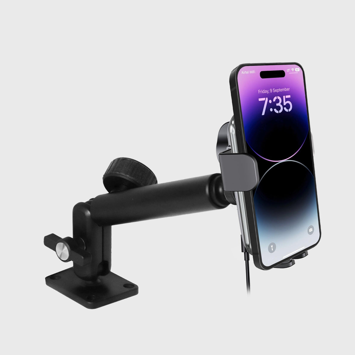 Close-up of the wireless car charger mounted on the industrial mount, showing the clamp holding a smartphone with a digital clock display.