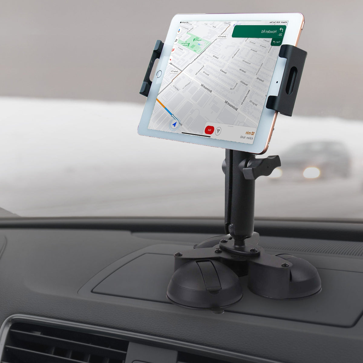 Black industrial tablet mount with suction cups, mounted on car windshield, used for hands-free device operation, SKU: M9500-B3